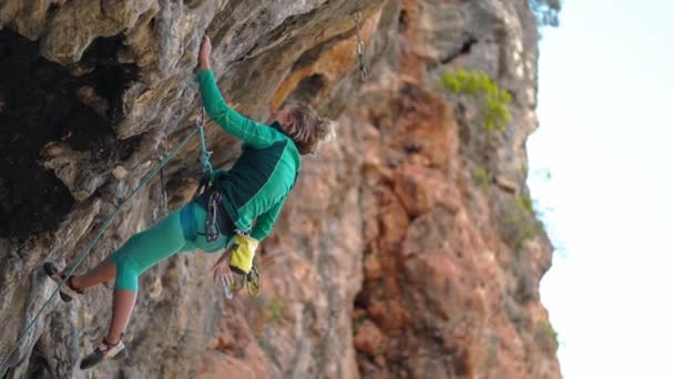 Fuerte escalador de roca hembra sube duro difícil difícil ruta de roca en la pendiente de peñasco negro. montaña y escalada al aire libre — Vídeo de stock