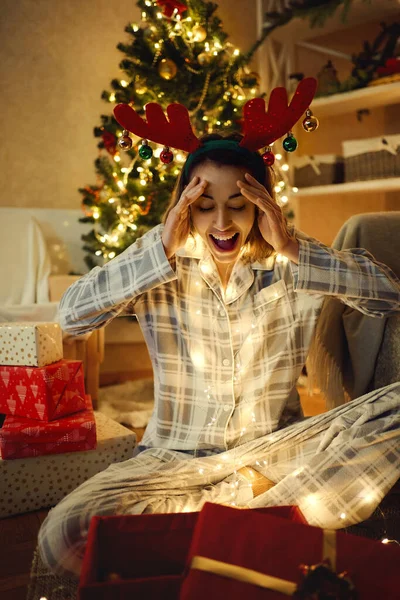 Yllättynyt juhlava nainen saa suuren lahjan joulun aikaan — kuvapankkivalokuva