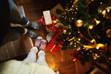 Noel çoraplı çift Noel ağacının yanında hediye ve hediye kutularıyla