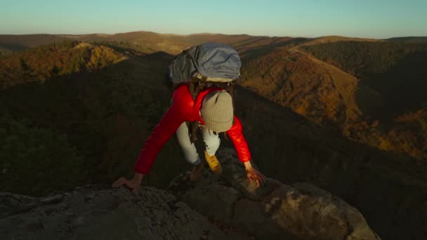 Rallentatore di maschi mano tesa e aiutare escursionista femminile raggiungere cima scogliera tirandola su dal bordo. POV uomo dando mano alla donna arrampicata sulla scogliera e aiutarla a raggiungere la cima. escursione autunnale — Video Stock