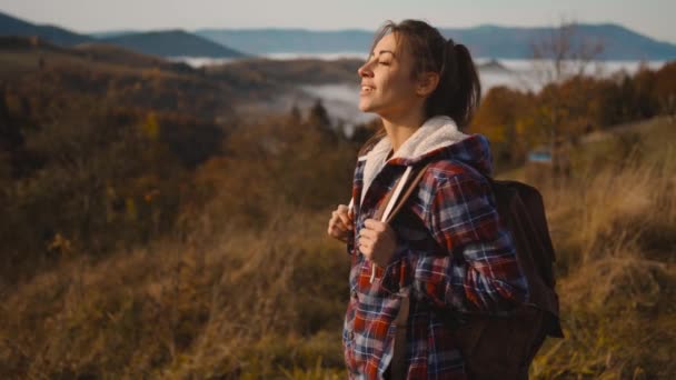 Hipster millennial jonge vrouw loopt op de top van de berg top bij zonsopgang, vooruit kijken, genieten van een prachtig uitzicht, gelukkig en dronken van het leven, jeugd en gelukkig — Stockvideo
