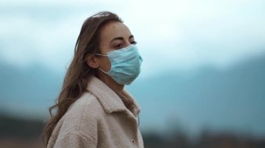 Mutlu gezgin kadın koruyucu maskesini çıkarırken dışarıda duruyor ve Covid19 'dan gelen aşılardan sonra kafasını kaldırıyor. Artık güvendeyiz, koronavirüs bitti, karantina sona erdi.