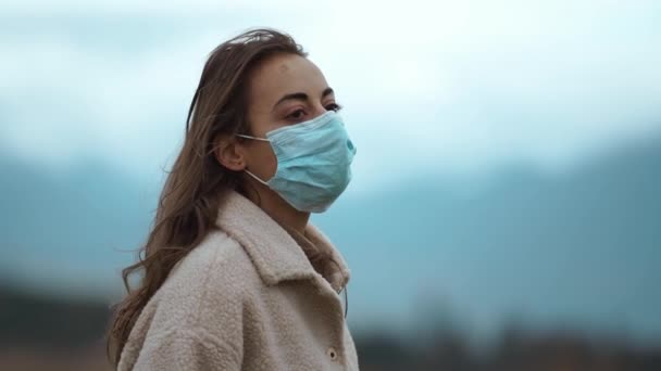 幸せな旅行者の女性は彼女の保護顔マスクを脱いで、 Covid19からの予防接種後の世話をしながら屋外に立っています。我々は今安全だコロナウイルス終了隔離は概念以上だ — ストック動画