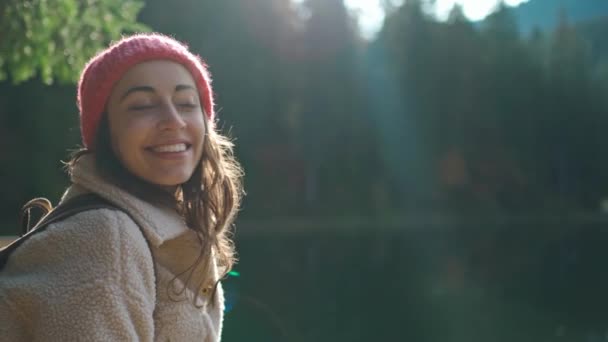 Портрет счастливой веселой женщины-туристки на красивом горном озере с бирюзовой водой наслаждается удивительным спокойным осенним пейзажем. красота дикой природы, здоровый образ жизни — стоковое видео