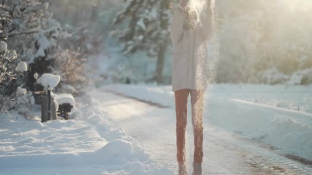 4k Lento movimiento Mujer joven lanzando nieve en el parque de invierno. Chica divirtiéndose al aire libre. Actividades de invierno — Vídeo de stock