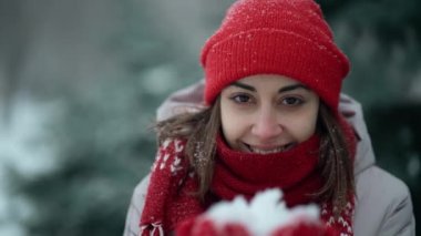 woman showing Snow. Beauty Joyful Model Girl having fun in winter park holding snow in hands. Enjoying nature. Slow motion video footage 60 fps 4k