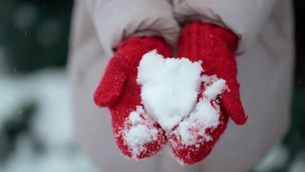 Snow like heart shape in hands. Female hands in warm red mittens with snowy heart. I love winter or St.Valentines Day romantic creative concept — Αρχείο Βίντεο