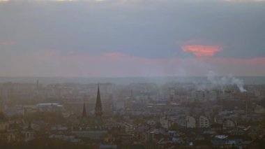 Şehrin üzerinde parlak turuncu gün batımı ve silueti. Lviv, Ukrayna