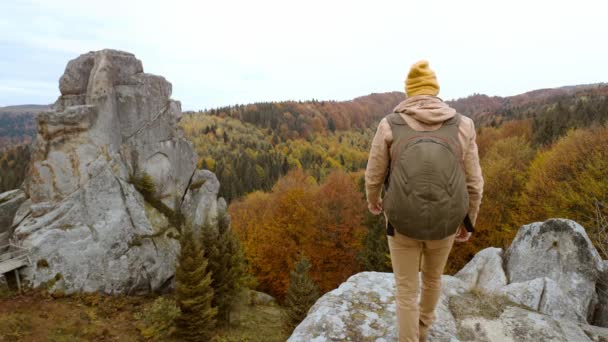 Zadní pohled pár turistů stojí na podzimní krajině pozadí s útesy v národním parku Tustan, Ukrajina. láskyplný něžný muž a žena cestující spolu a jednota s přírodou — Stock video