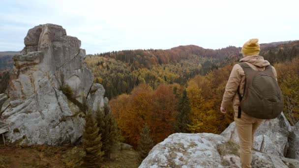 Ukrayna 'nın kayalık ulusal parkı Tustan' da el ele tutuşan çift romantik manzarada yürüyüş yapıyor. Yürüyüş yapan erkek ve kadın âşıklar dağlarda sırt çantalarıyla yürüyorlar. — Stok video