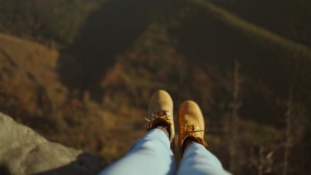 Close-up wandelschoenen van Independent Woman reiziger op de top van de berg te kijken naar het uitzicht. Wandelaar meisje bungelen voeten over rand van klif genieten vakantie reizen avontuur Karpaten bergen, Oekraïne. — Stockvideo