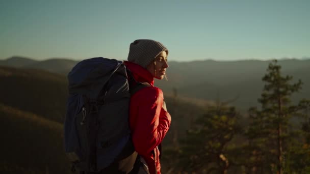 Une jeune femme se tient debout au sommet d'une montagne et regarde le coucher du soleil. Belle fille jouit de la liberté dans les montagnes, heureux et ivre sur la vie, la jeunesse et le bonheur. — Video