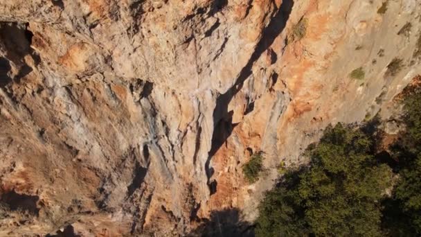 Drönare som flyger ut från kalkstensklippan med bergsklättrare på. man klättrar utmanande rutt på vertikal spricka — Stockvideo