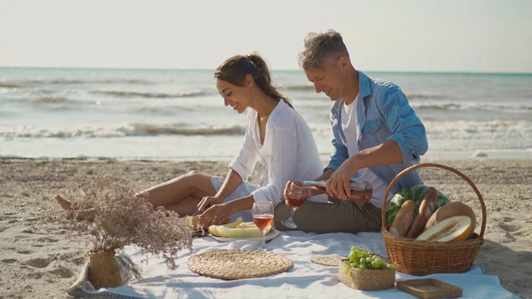 Vakkert par som har en romantisk date på stranda og lager frokost sammen. – stockfoto