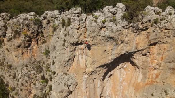 Letecký pohled z dronu silného atletického muže skalního horolezce sestupuje z vysokého svislého útesu na horním laně. zdravý životní styl a sportovní aktivity v Turecku. Záběry 4k stok — Stock video