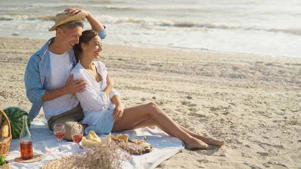 Nuori ja onnellinen kaksi ystäville nauttia romanttinen piknik viiniä. Treffit meren rannalla — kuvapankkivalokuva