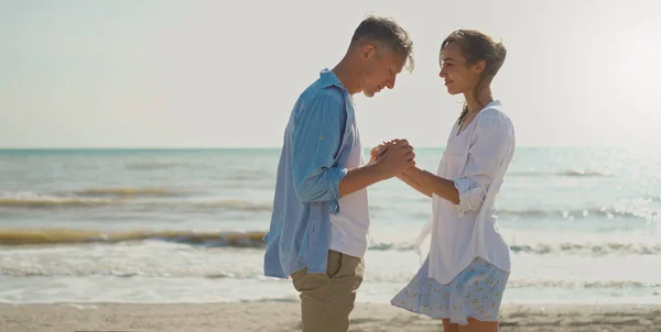 Kaunis romanttinen pari aurinkoisella rannalla, mies tekee kosinnan tyttöystävä, — kuvapankkivalokuva