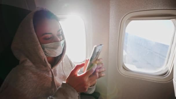妇女乘客在靠窗的飞机座位上放松，带着飞艇和电话. — 图库视频影像