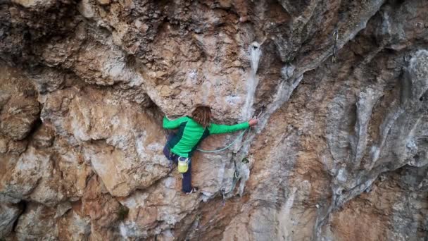 映画の登山の瞬間。強力な女性登山家のスローモーション映像キャビナーへの非常にハードオーバーハングルートクリッピングロープを登るとハード移動を行う。テルキー、ゲイキバイリー — ストック動画