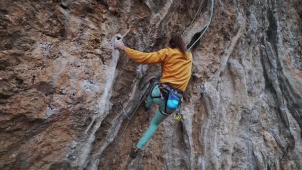 Zpět pohled na silného šikovného muže skalní horolezec leze přes převislou obtížnou cestu s skalní tufa, dělá velmi těžké pohyby, snaží se uchopit rukojeti na kolonet a pádu. — Stock video