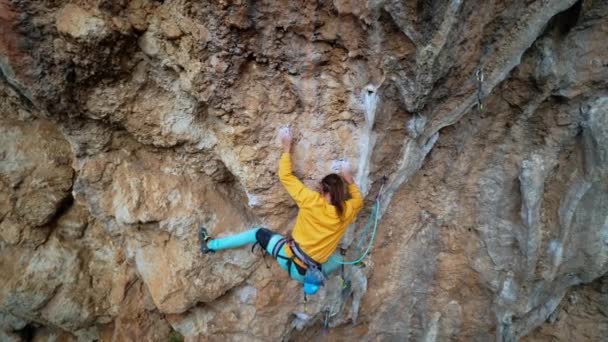 Geschickter athletischer männlicher Felskletterer, der sich beim Klettern an überhängenden Felswänden ausruht. Mann mit Beinen zur Befestigung an der Wand und zum Ausruhen vor schwierigen Anstrengungen und Bewegungen. — Stockvideo