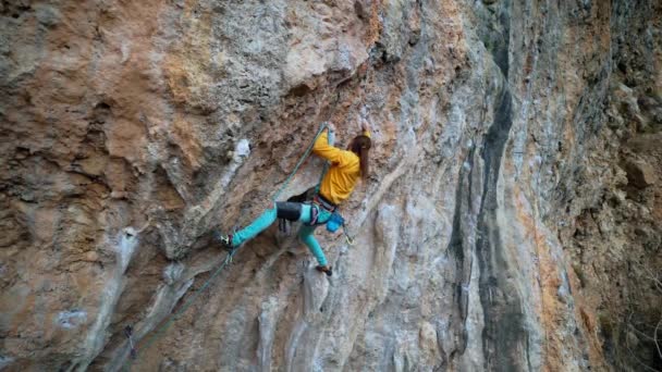 Starker Mann Bergsteiger klettert in Zeitlupe auf überhängenden Kalksteinfelsen mit Kolonien. Mann benutzt Kniescheibe an Wand zum Ausruhen und Abschneiden von Seilen — Stockvideo