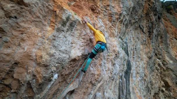 空中慢动作后视镜强壮有力的男子攀岩者爬上悬着的石灰岩悬崖 — 图库视频影像