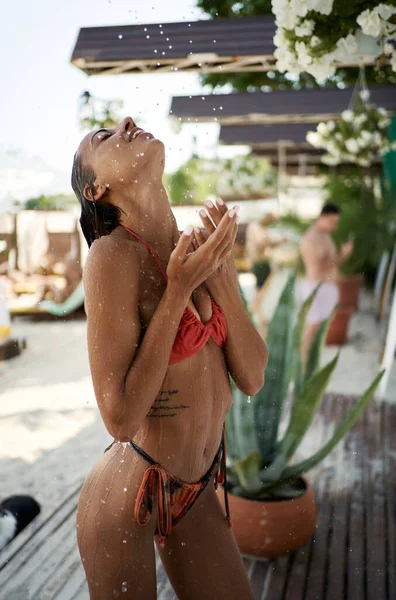Perfect lichaam gebruinde huid model in bikini genieten van warme tropische strand douche — Stockfoto
