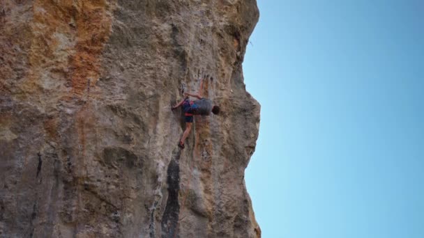 Sterke en bekwame man klimmer klimt op verticale kalkmuur kruipen door uitdagende route, maakt harde inspanning en grijpt houden. extreme sport en gezonde levensstijl — Stockvideo