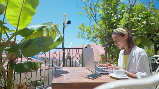 Side view fiatal női üzletasszony használja laptop szabadban teraszon pálmafákkal, távoli online dolgozik a nyári vakáció alatt — Stock videók