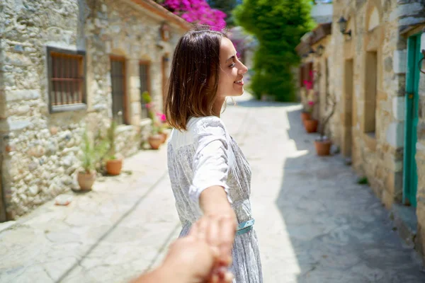 Carefree joyful woman holding someone hand like follow me at sunny street — Stock Photo, Image