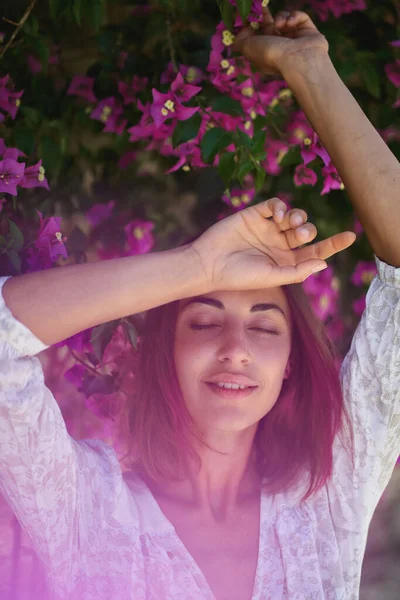 Primavera beleza retrato deslumbrante jovem posando no jardim com flores rosa — Fotografia de Stock