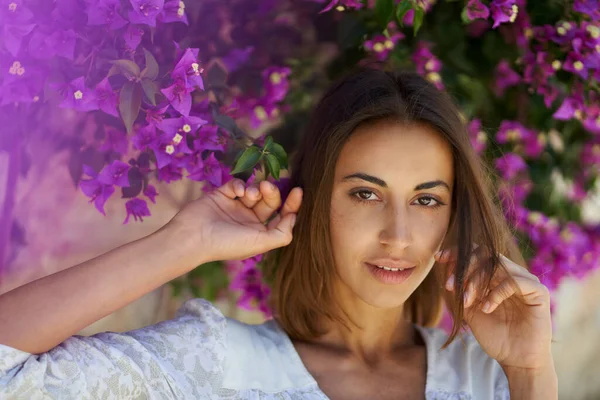 Schoonheidsportret jonge aantrekkelijke vrouw in de lente tuin met roze bloemen — Stockfoto
