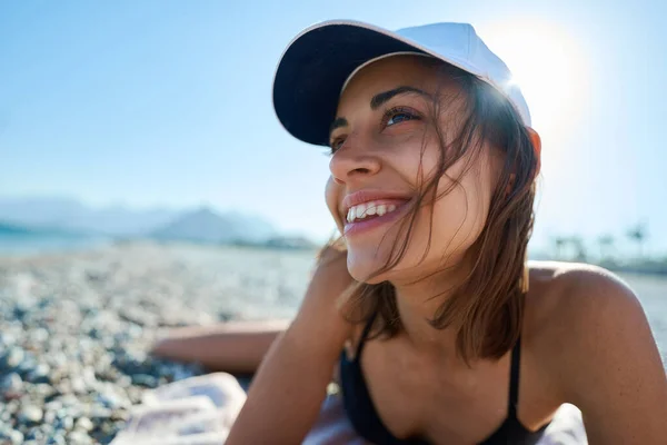 खुश जवान महिला धूप के समुद्र तट पर पड़ी और गर्मियों की छुट्टी के दौरान दूर देख रही . — स्टॉक फ़ोटो, इमेज
