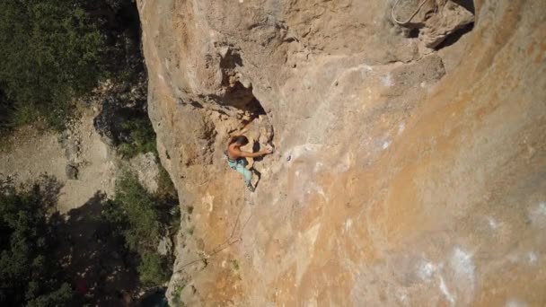 Vista superior homem bonito forte escalador de rocha sobe a parede de calcário ensolarado por rota desafiadora. atividade ao ar livre, estilo de vida ativo e conceito de esporte. escalada na Turquia. — Vídeo de Stock