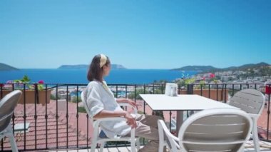 Genç melez bir kadının portresi. Açık terasta oturuyor. Hindi otelindeki güzel deniz manzaralı bir otelde.