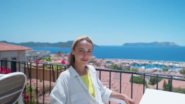 Retrato con efecto de paralaje de la joven mujer sonriente de raza mixta sentada en una terraza abierta con hermosa vista al mar en el hotel en turkey resort — Vídeos de Stock