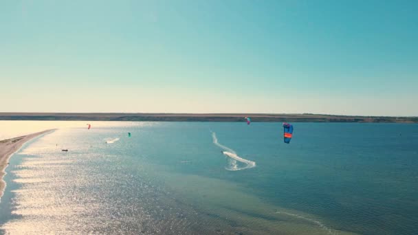 Kiteboarding na Ucrânia, região de Mykolaiv. Pára-quedas coloridos de pipas surf na água azul — Vídeo de Stock