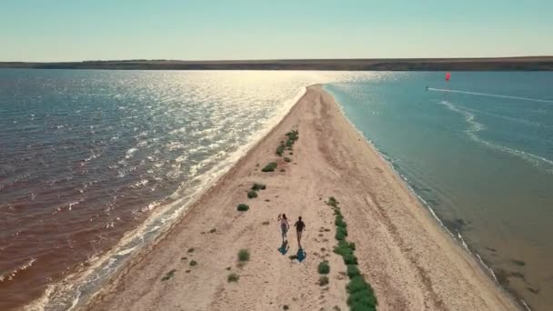 Hombre y mujer corriendo por la playa de arena entre el agua, san dbar en la región de Mykolaiv, Ucrania — Vídeo de stock
