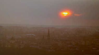 Şehrin üzerinde parlak turuncu gün batımı ve silueti. Lviv, Ukrayna