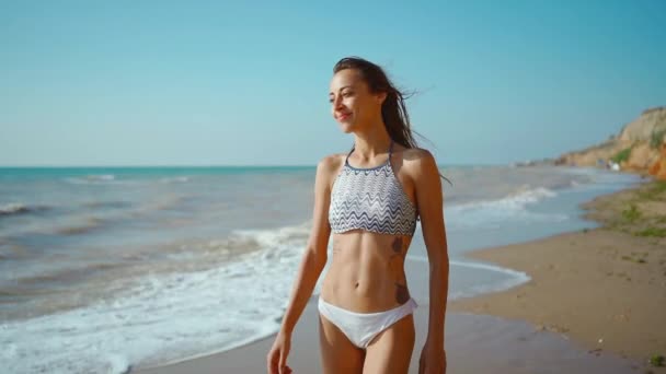 Cámara lenta de feliz alegre y delgado fitbody mujer vistiendo en bikini y disfrutando del viento y las olas en la costa del mar después de la tormenta. — Vídeo de stock