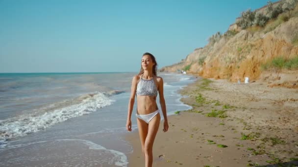 Ralenti du joyeux joyeux slim fitbody femme porter en bikini et profiter du vent et des vagues sur la côte de la mer après la tempête. — Video