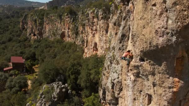 Vue aérienne depuis le drone d'un fort homme athlétique grimpeur descend de la haute falaise verticale sur la corde supérieure. mode de vie sain et activité sportive à l'extérieur en Turquie. séquences 4k stok — Video