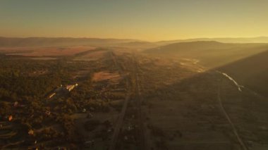 Güneşin doğuşunda sisli dağ geçidini gösteren hava aracı görüntüsü. Sürücü arabaları ve demiryolu olan bir yol. Sakinlik, rahatlama, yalnızlık, Karpatlar 'da doğa, Ukrayna. hedef ve ulaşım.