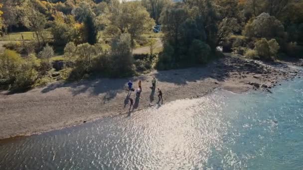 Des images aériennes de drones survolant la rivière Srtiy dans les Carpates, en Ukraine. ciel bleu profond, eau claire, feuillage jaune d'automne orange et personnes se reposant sur le rivage de la rivière — Video