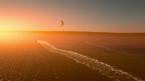 Luftudsigt slow motion aktiv mand kiteboarding og windsurfing på smukke solnedgang, aktiv livsstil ekstrem sport koncept. Ukraine, Mikolaiv-regionen. – Stock-video