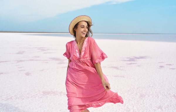 Beautiful happy woman emotionally smile to camera, wearing pink dress. Ukraine Sivash pink lake Stock Image