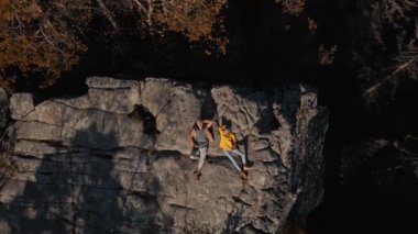 Uçurumun tepesinde uzanan mutlu çift otostopçuları. Erkek ve kadın gezginler Ukrayna 'nın Karpat dağlarında manzaranın tadını çıkarıyorlar. Mutlu kız ve erkek doğada birlikte dinleniyorlar.