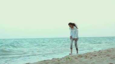 Güzel bir yaz kadını ılık güneşli bir akşamda dalgalarla deniz suyunda yürüyor, akıcı beyaz bir gömlek giyiyor. Özgürlük ve cennet kavramı