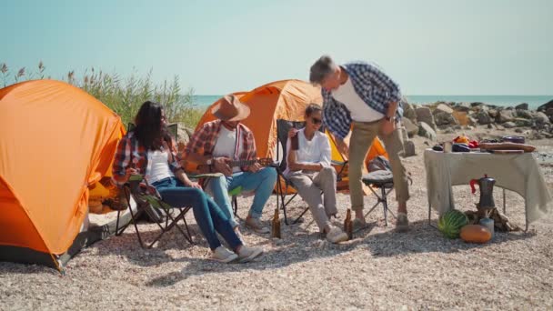 의자에 해변에서 캠핑을 휴식을 취한다 해변에서 피크닉에 친구들이 맥주를 마십니다 — 비디오